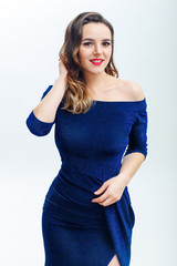 Cute young woman in navy blue dress on white background