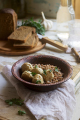 Meatballs in sour cream sauce, served with buckwheat porridge, bread and garlic. Rustic style.