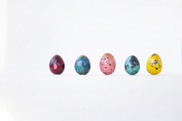 On a white background are painted eggs. Real hand-painted eggs. A multi-faceted photo. Holiday and joy of Bright Easter for the whole family