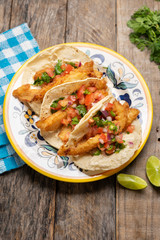 Mexican breaded fish tacos also called ensenada on wooden background