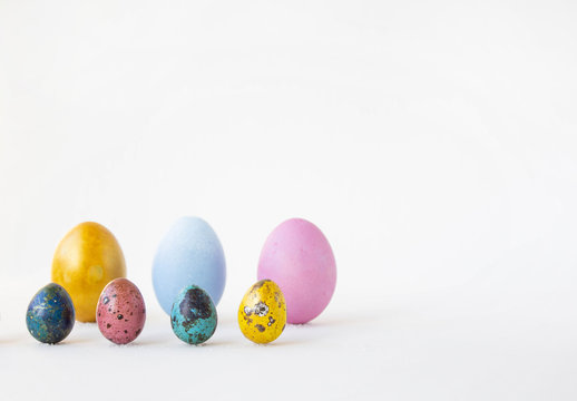 Eggs are painted on a white background. Small and large hand-painted eggs. Multi-faceted photography. Holiday and joy of Bright Easter for the whole family