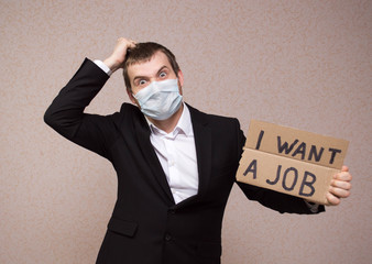 lose job Unhappy businessman with surgical medical mask is looking at job with a sign in his left...