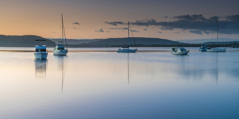 Fototapeta na wymiar Boats and a Bay Sunrise Waterscape Panorama
