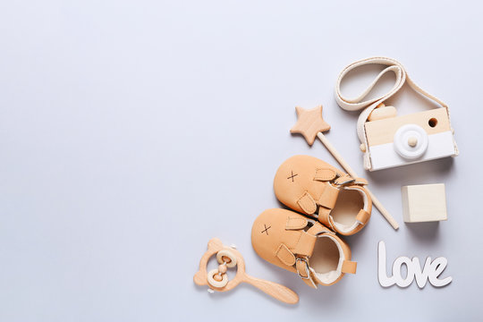 Set Of Baby Shoes, Toys And Accessories On Grey Background. Newborn Stuff. Flat Lay, Top View