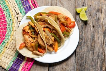 Mexican chicken fajitas tacos on wooden background