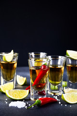 five glasses of alcohol and lime and red chili, a party at the bar, a menu for the bar. Selective focus and copy space, Tequila shots, vodka, whisky, rum