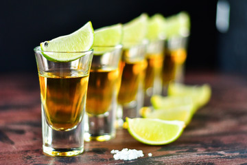 five glasses of alcohol and lime and red chili, a party at the bar, a menu for the bar. Selective focus and copy space, Tequila shots, vodka,whisky, rum