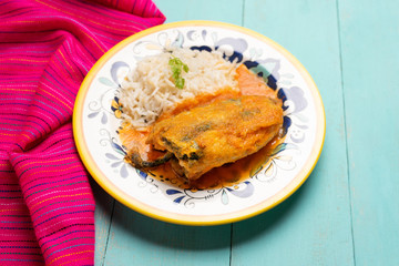 Mexican chili-stuffed poblano with rice on turquoise background