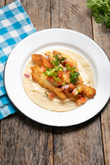 Mexican breaded fish tacos also called ensenada on wooden background