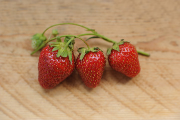 Ripe strawberries on wooden table. Fresh strawberries on brown wooden background. Delicious and healthy vegetarian food.