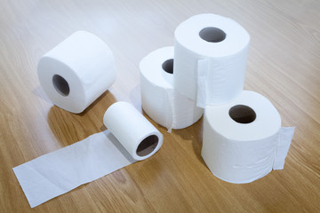 toilet paper stacked on wooden floor