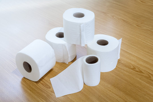 toilet paper stacked on wooden floor