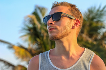 young handsome bearded guy in black sunglasses close up, looking away