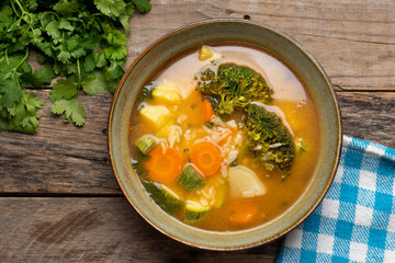 Vegetables soup with rice on wooden background