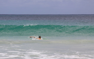 Swimmer in ocean waves at Mawun beach Lombok, Indonesia