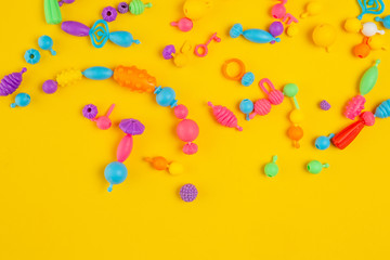 Obraz na płótnie Canvas Colored kids toys on yellow background.