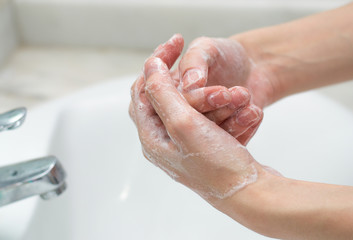 Hand washing with soap and water to prevent the spread of bacteria and viruses like coronavirus or covid-19