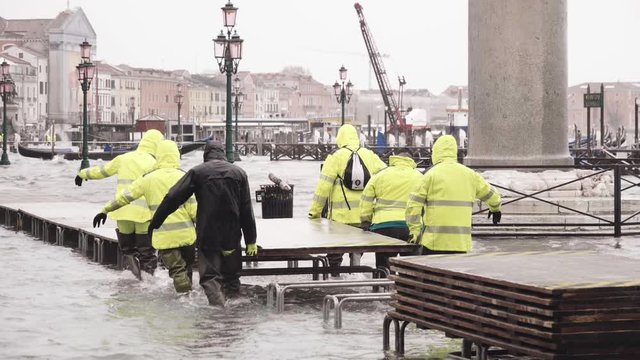 VENICE, ITALY - November 12, 2019: Workers installing bridge during flood (acqua alta) in Venice, Italy. Venice high water. Slow motion