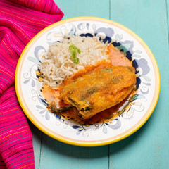 Mexican chili-stuffed poblano with rice on turquoise background