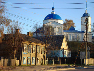 Fototapeta na wymiar Rostov, Golden Ring of Russia, Yaroslavl Region, Russia - April 30, 2012 Old house on the street in front of an Orthodox church with domes with crosses for Easter