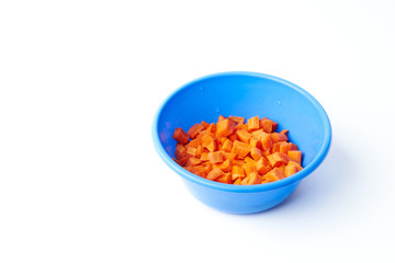 Sliced raw carrot in a plastic bowl isolated on a white background.