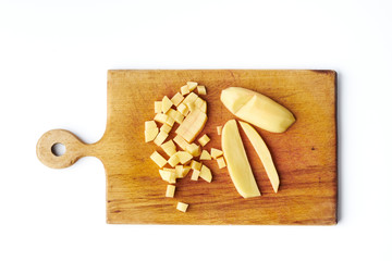 Sliced raw potatoes on a cutting board isolated on a white background.