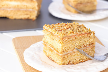 Two pieces of homemade honey cake on white wooden table.  Selective focus.