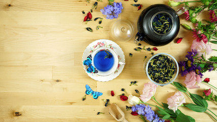 Premium Blue Butterfly Pea Flower herbal tea is a caffeine-free herbal tea beverage made from the infusion of the flower petals of the Clitoria ternatea plant. Creative layout flat lay.