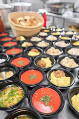 Food delivery. Different in plastic disposable lunch box with healthy natural food. Chicken broth, mashed soup, mashed potatoes with cutlet, seafood pasta, salads, pilaf with a fresh bun.