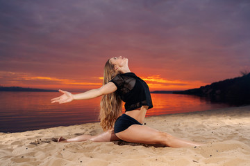 Fototapeta na wymiar girl doing pilates, yoga on the beach, at sunset 