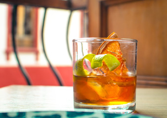 
whiskey cocktail with orange and lemon wedges