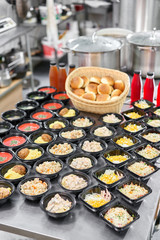 Food delivery. Different in plastic disposable lunch box with healthy natural food. Chicken broth, mashed soup, mashed potatoes with cutlet, seafood pasta, salads, pilaf with a fresh bun.
