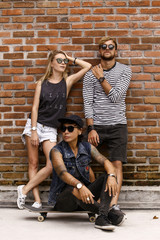 company of friends of skaters on the background of a brick wall.