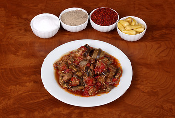 very beautiful stew with eggplant tomatoes on a white plate with Turkish spices on wooden table