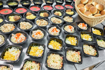 Row of plastic disposable lunch box with healthy natural food. Soups, cream soup, main course with side dish, salads. Food delivery. Lunch in the office.