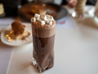 Glass of hot cacao drink with marshmallow topping