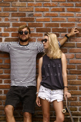 company of friends of skaters on the background of a brick wall.