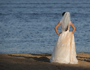 Fototapeta na wymiar bride on the river bank, lonely bride on the beach