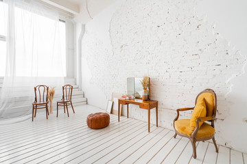 Interior photo Studio. Morning in light interior. Bright and clean interior design of a luxury living room with wooden floors, fireplace, sofa and chair . Stucco on walls