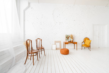 Interior photo Studio. Morning in light interior. Bright and clean interior design of a luxury living room with wooden floors, fireplace, sofa and chair . Stucco on walls