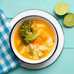 Vegetables soup with rice on turquoise background