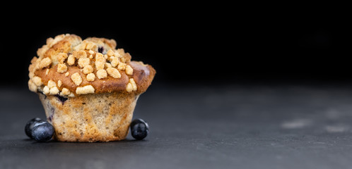 Fresh made Blueberry Muffins on a slate slab (close-up shot; selective focus)