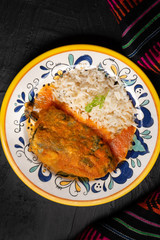 Mexican chili-stuffed poblano with rice on dark background