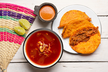 Mexican birria consomme and beef tacos on white background