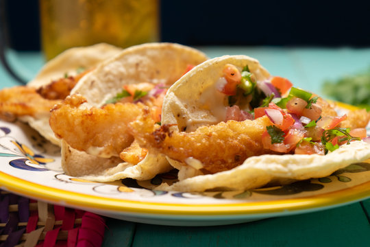 Mexican breaded fish tacos also called ensenada on turquoise background