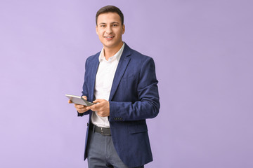 Young man with calculator on color background