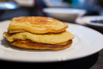 Fresh plane homemade classic pancakes with no maple syrup on a white plate.