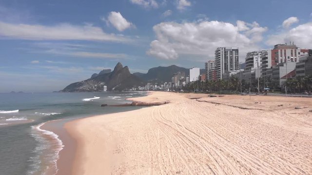 Aerial approach of a large rusty pipeline revealed in Ipanema after a strong tidal wave washed away much of the beach sand with empty beach due to the COVID-19 Corona virus outbreak [April 15, 2020]