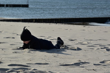 dziecko, plaża, wiosna, jesień, zabawa, słońce, hartowanie, czapka, kurtka, miki, czarny, piasek, radość, dzieciństwo, Kołobrzeg, wydmy, Morze Bałtyk, morze, bałtyckie,  spacer, pustynia, 