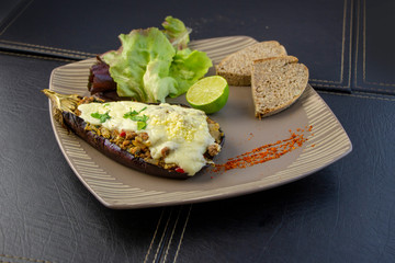 Platillo de berenjenas gratinadas, con lechugas y pan integral